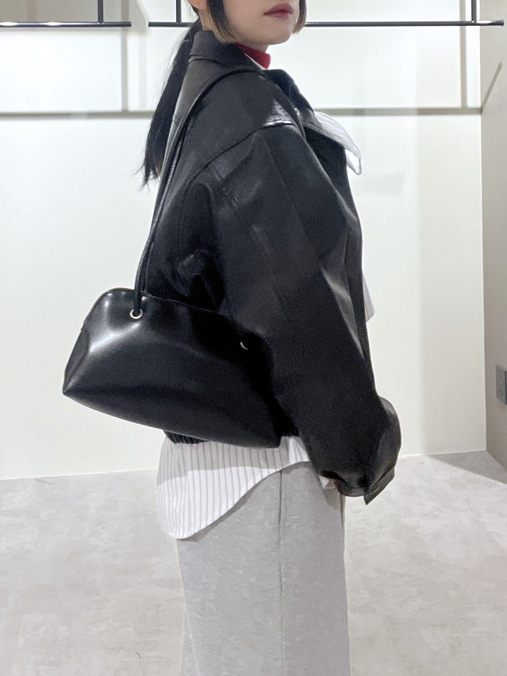 ホワイト系のシャツ/ブラウス、レッド系のニット/セーター、ブラック系のブルゾンを着用したレディースの冬コーディネートの4枚目の写真