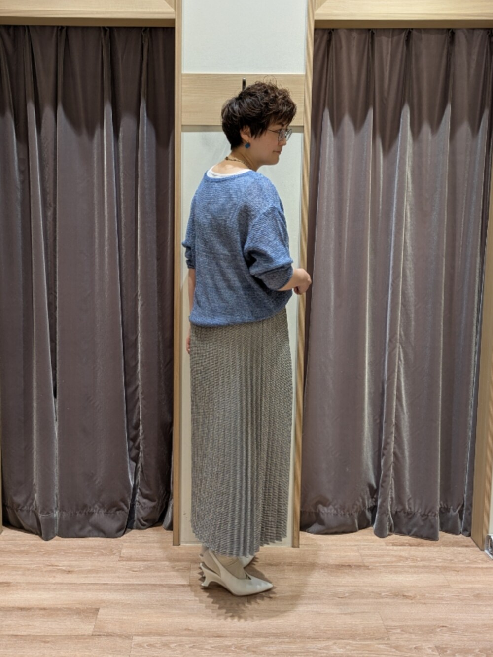 ホワイト系のパンプス、ホワイト系のハンドバッグ、ブルー系のニット/セーターを着用したレディースの春コーディネートの4枚目の写真