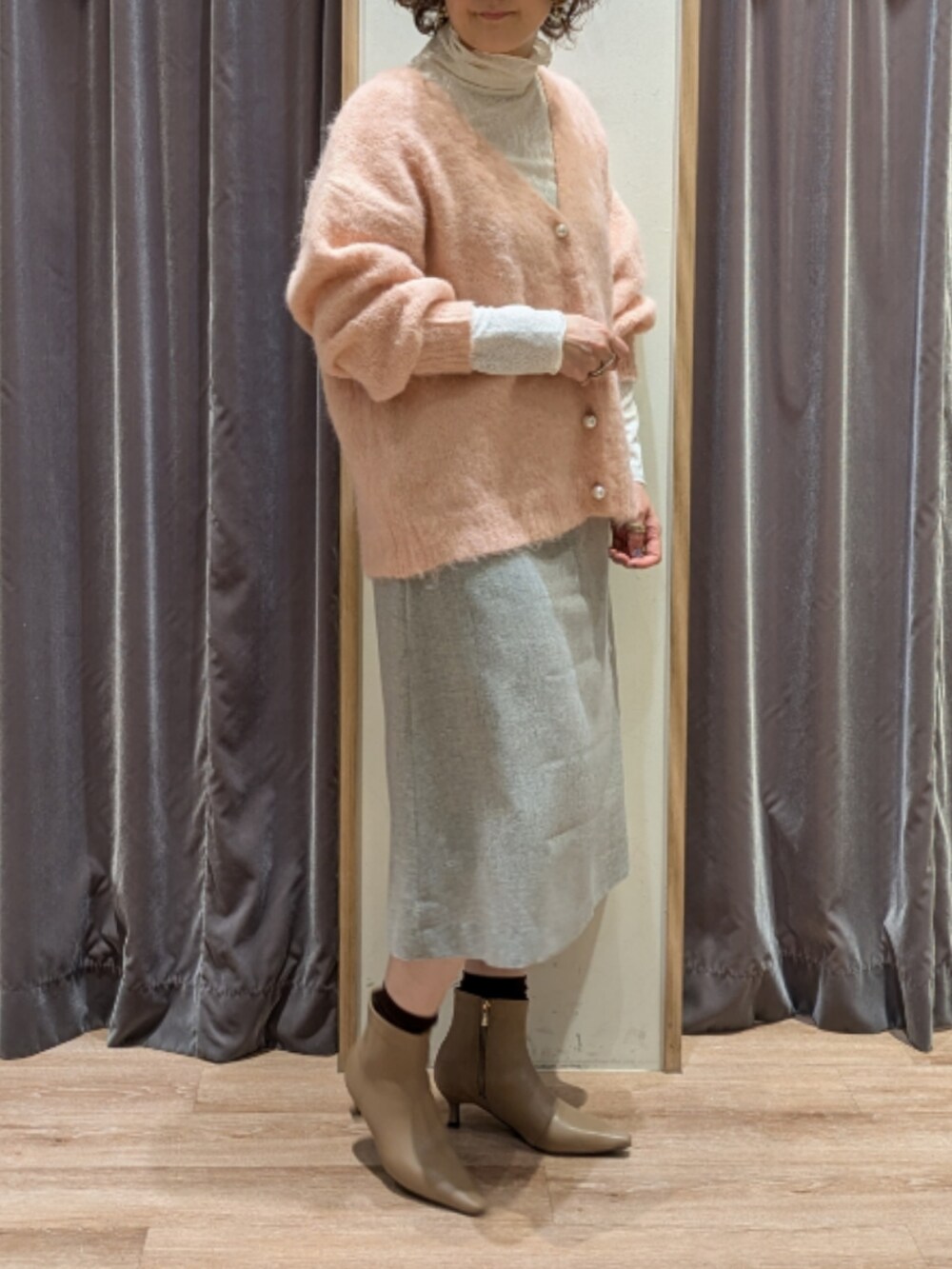 ホワイト系のハンドバッグ、ホワイト系のTシャツ/カットソー、ピンク系のカーディガン/ボレロを着用したレディースの冬コーディネートの2枚目の写真