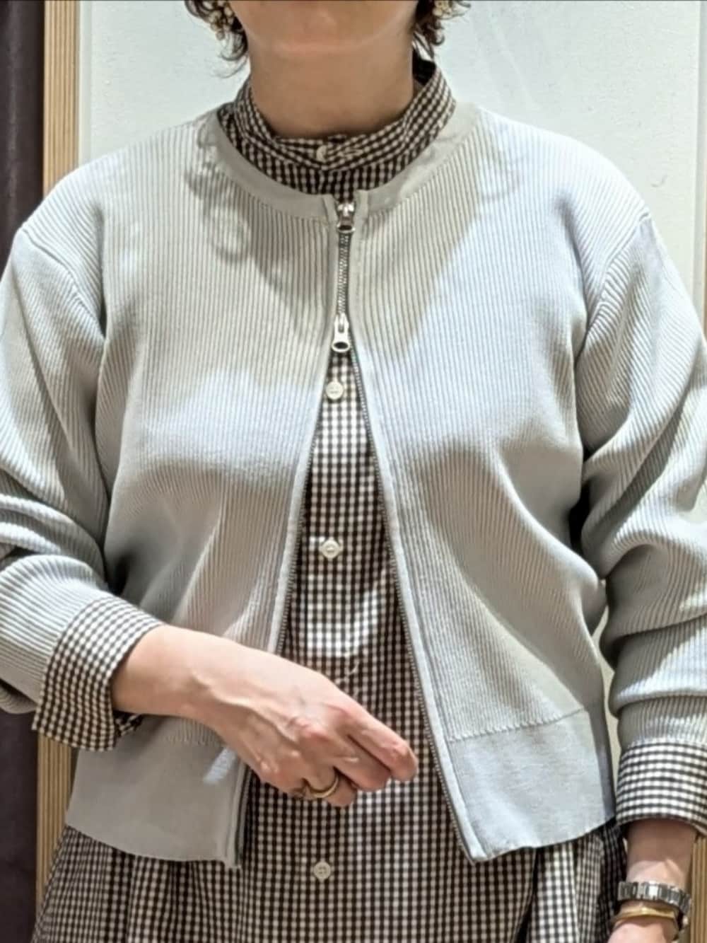 ブラウン系のワンピース、ホワイト系のハンドバッグ、ベージュ系のブーツを着用したレディースの秋コーディネートの2枚目の写真