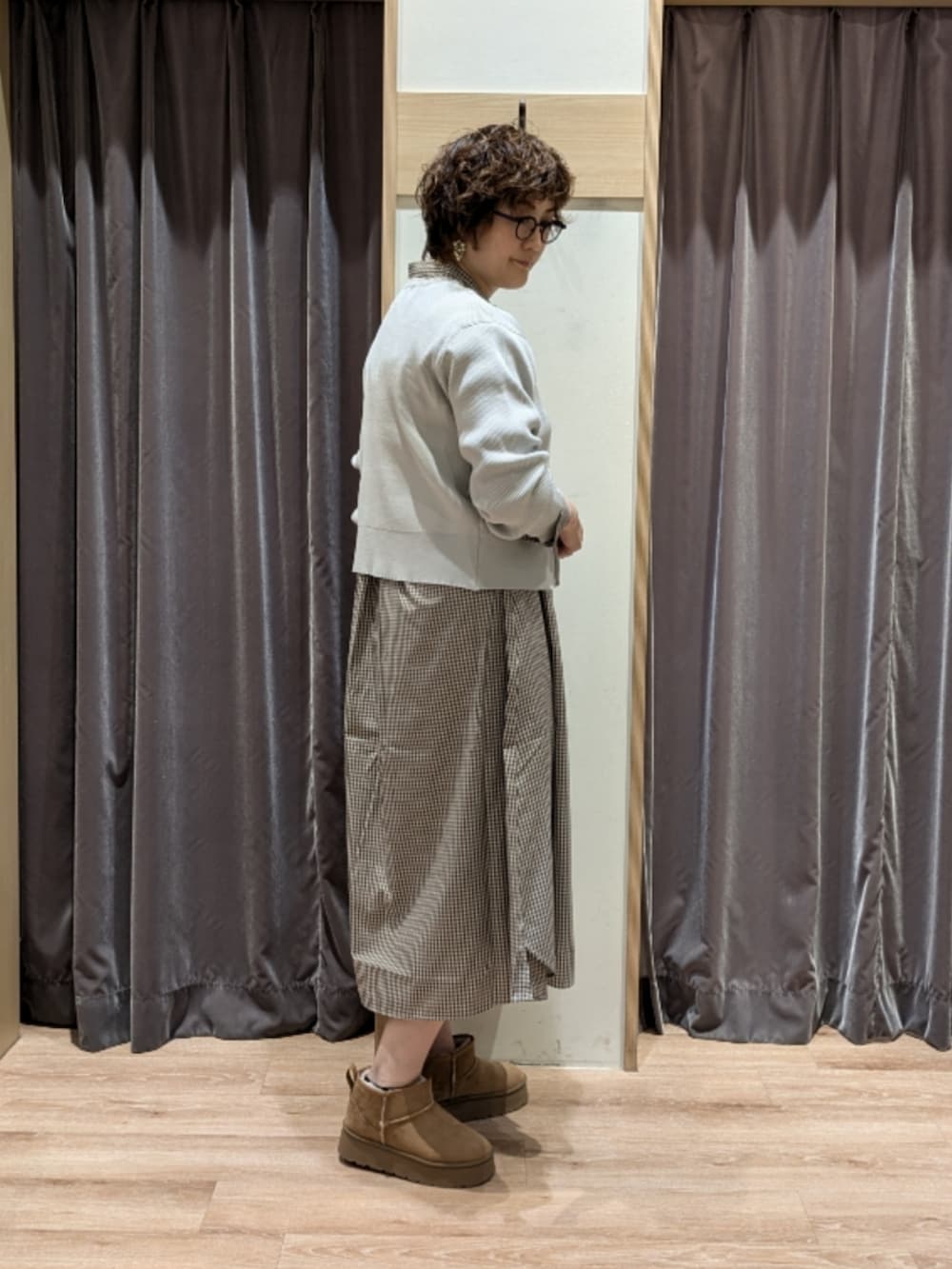 ブラウン系のワンピース、ホワイト系のハンドバッグ、ベージュ系のブーツを着用したレディースの秋コーディネートの3枚目の写真