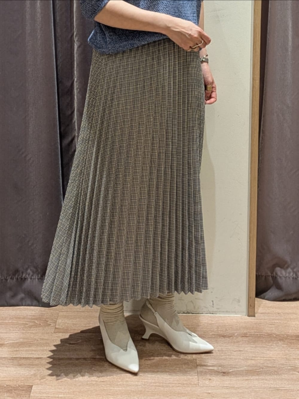 ホワイト系のパンプス、ホワイト系のハンドバッグ、ブルー系のニット/セーターを着用したレディースの春コーディネートの3枚目の写真