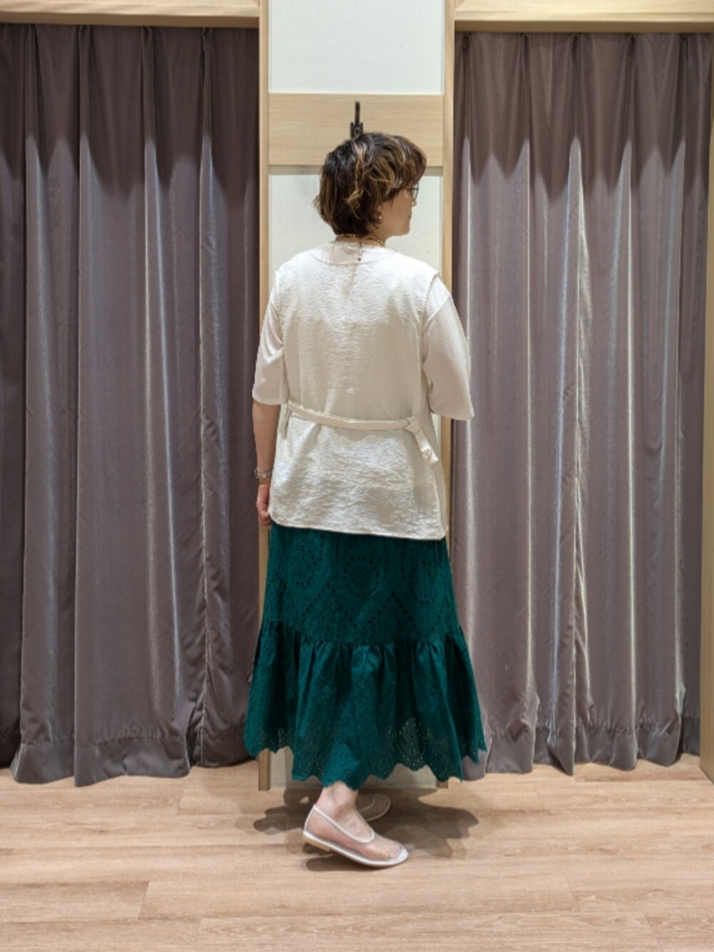 ホワイト系のその他シューズ、ホワイト系のハンドバッグ、グリーン系のスカートを着用したレディースの夏コーディネートの4枚目の写真