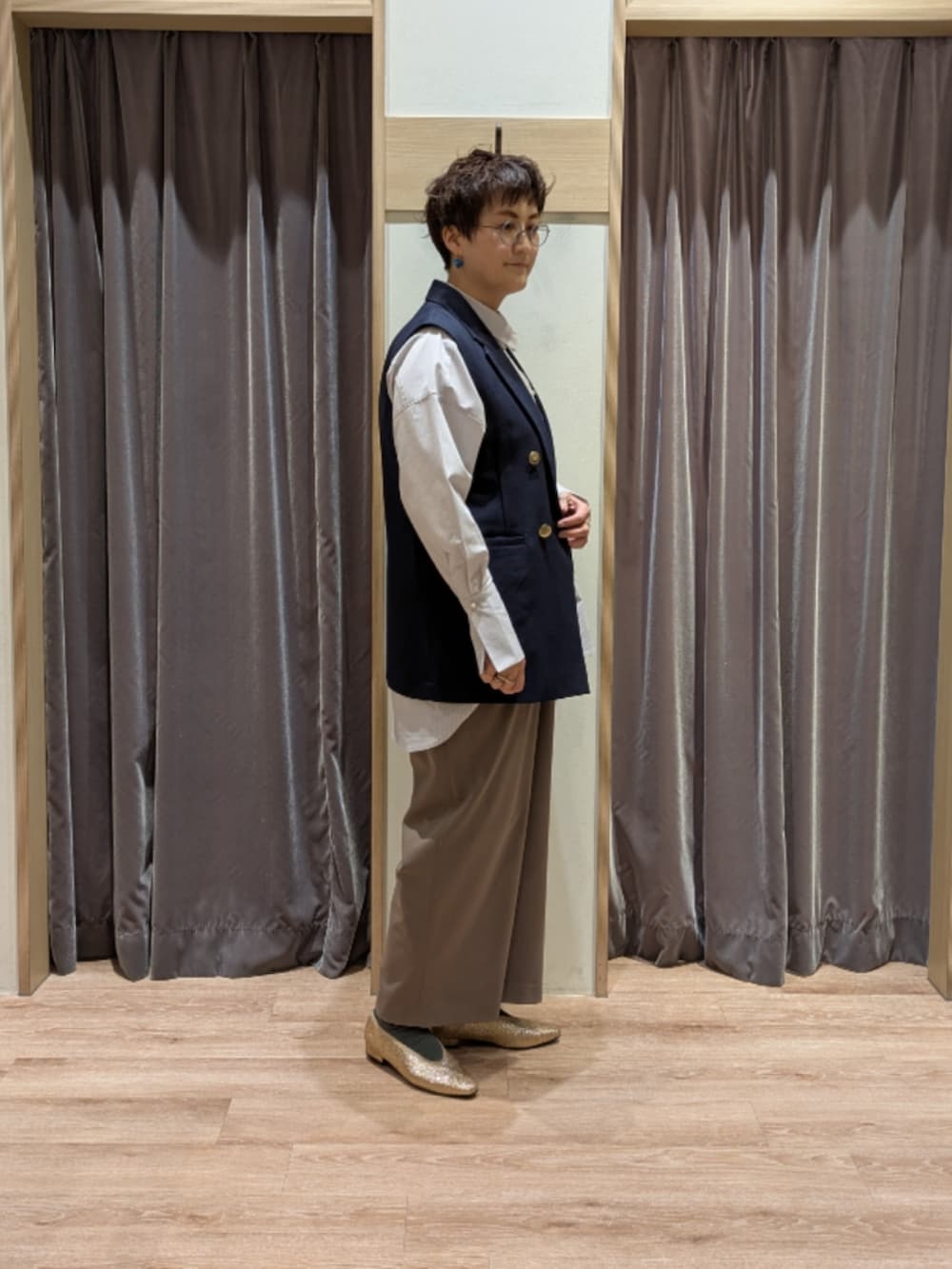 ブラック系のハンドバッグ、ゴールド系のパンプス、グレー系のシャツ/ブラウスを着用したレディースの冬コーディネートの2枚目の写真