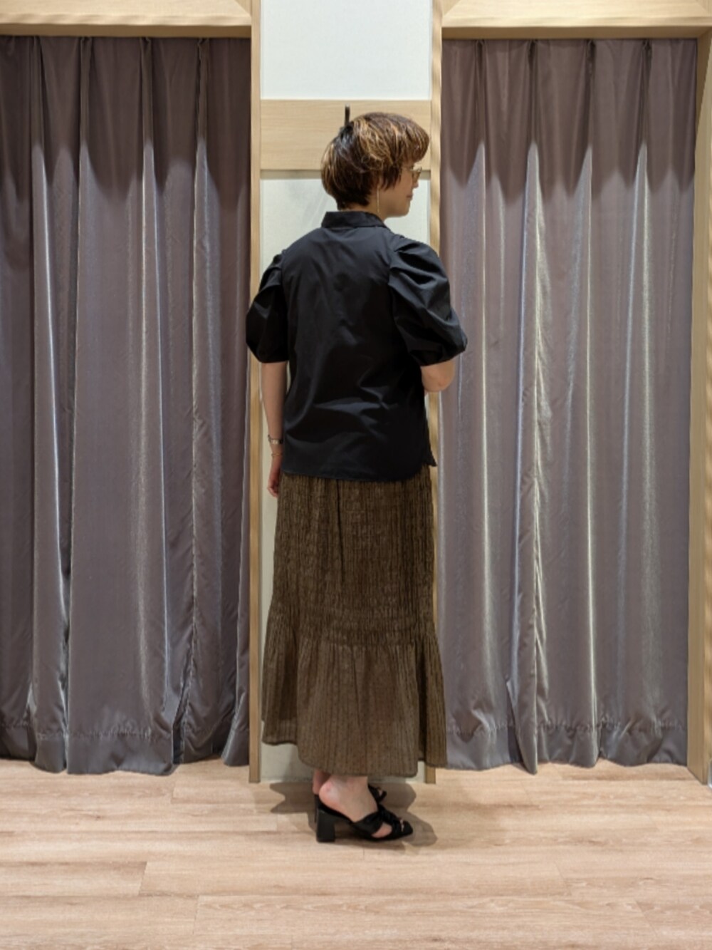 グリーン系のハンドバッグ、ホワイト系のノーカラージャケット、ブラック系のサンダルを着用したレディースの春コーディネートの4枚目の写真