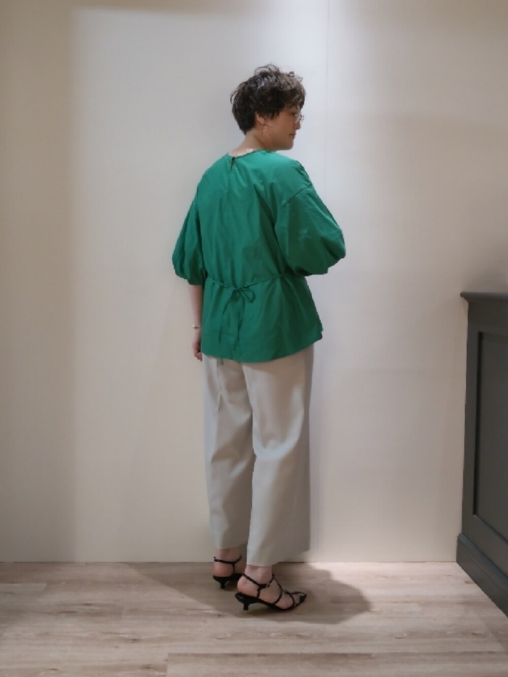 ブラック系のハンドバッグ、ブラック系のサンダル、グリーン系のシャツ/ブラウスを着用したレディースの春コーディネートの3枚目の写真