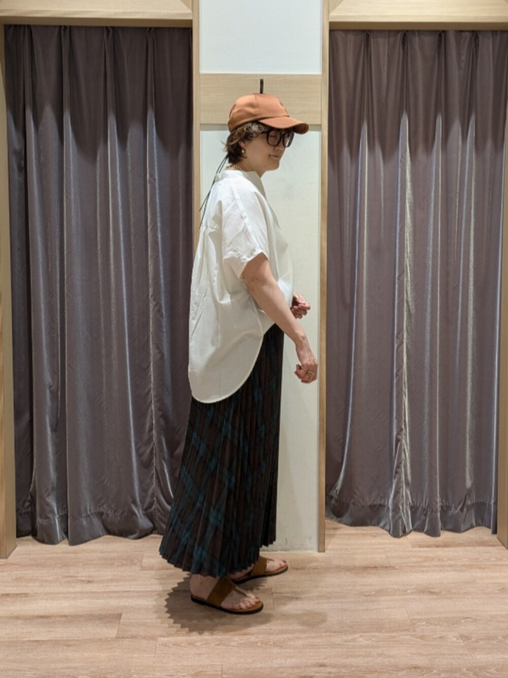 ブラウン系のハンドバッグ、ブラウン系のサンダル、ブラウン系のスカートを着用したレディースの春コーディネートの2枚目の写真