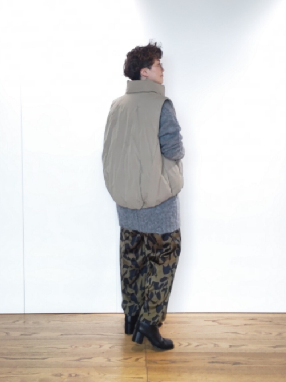 グリーン系のハンドバッグ、グレー系のニット/セーター、ブラック系のブーツを着用したレディースの冬コーディネートの3枚目の写真