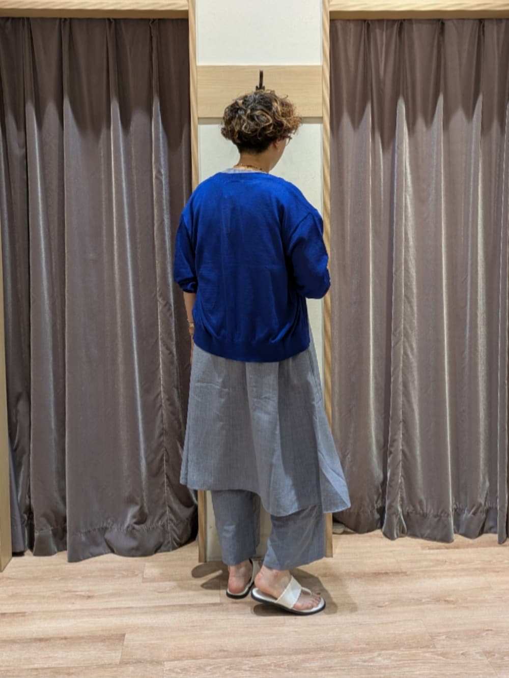 ベージュ系のハンドバッグ、ホワイト系のサンダル、ブルー系のカーディガン/ボレロを着用したレディースの夏コーディネートの2枚目の写真