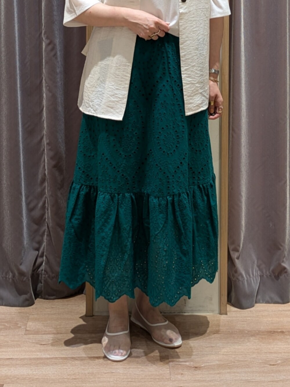 ホワイト系のその他シューズ、ホワイト系のハンドバッグ、グリーン系のスカートを着用したレディースの夏コーディネートの2枚目の写真