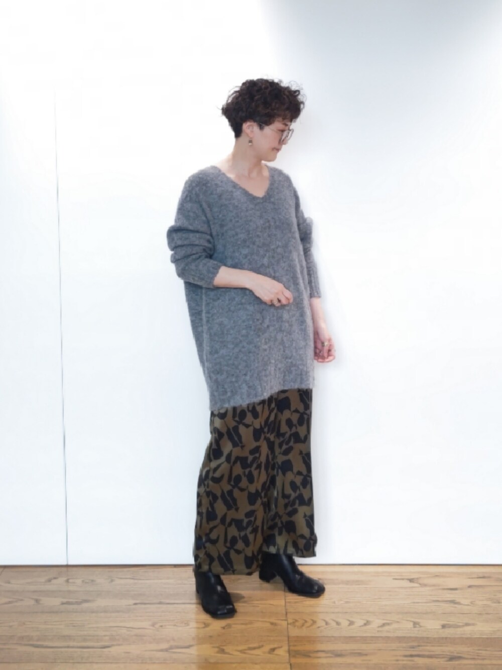 グリーン系のハンドバッグ、グレー系のニット/セーター、ブラック系のブーツを着用したレディースの冬コーディネートの4枚目の写真