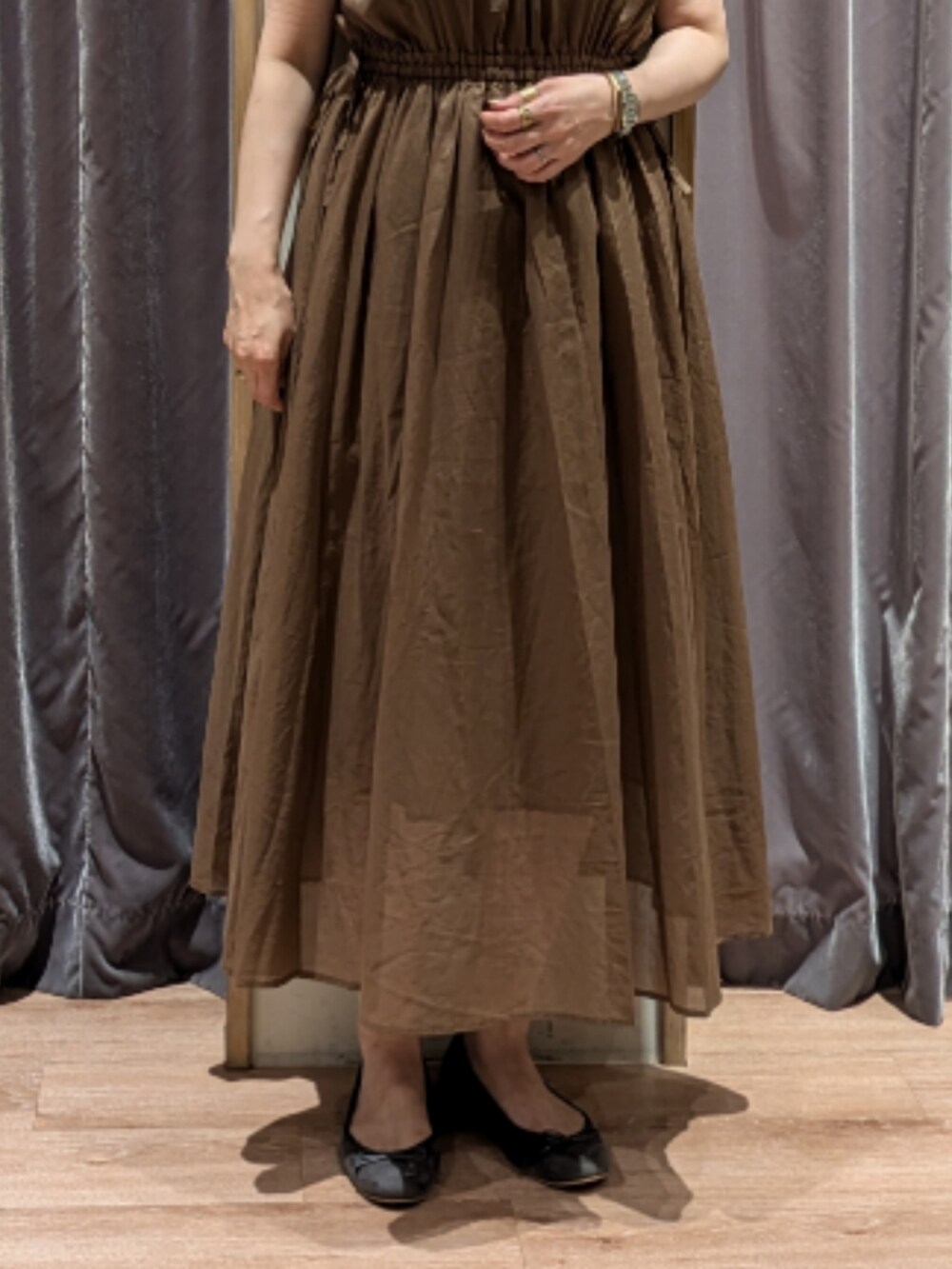 ホワイト系のハンドバッグ、グリーン系のワンピース、グレー系のノーカラージャケットを着用したレディースの夏コーディネートの4枚目の写真