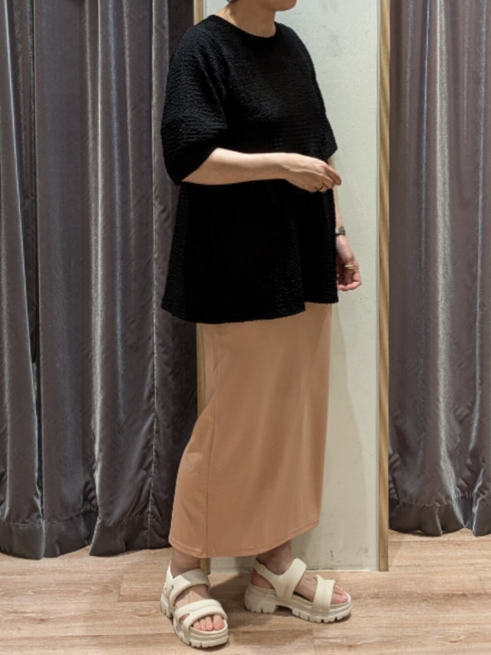 ブラック系のTシャツ/カットソー、ピンク系のスカート、ブラック系のハンドバッグを着用したレディースの夏コーディネートの2枚目の写真
