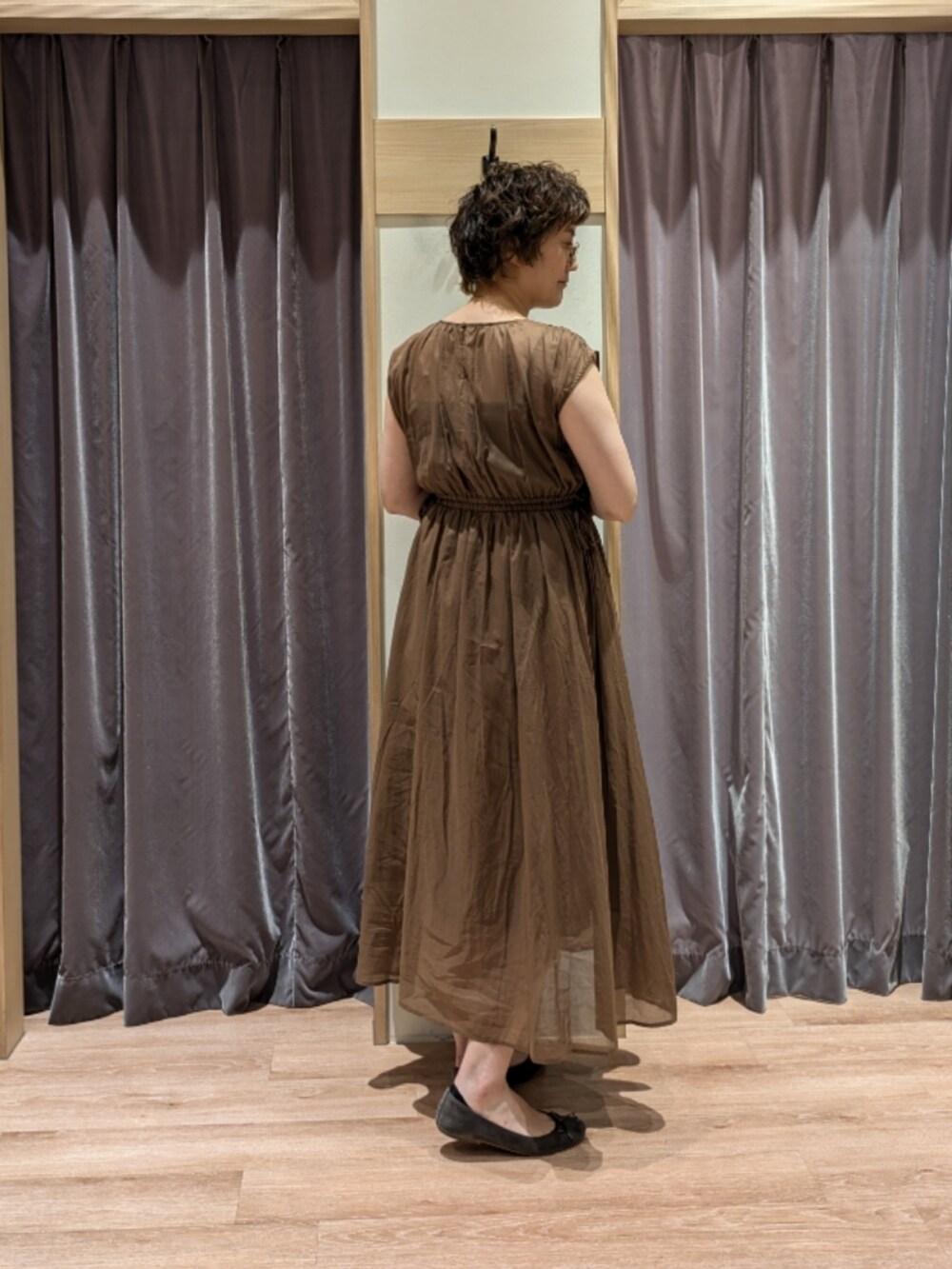 ホワイト系のハンドバッグ、グリーン系のワンピース、グレー系のノーカラージャケットを着用したレディースの夏コーディネートの5枚目の写真