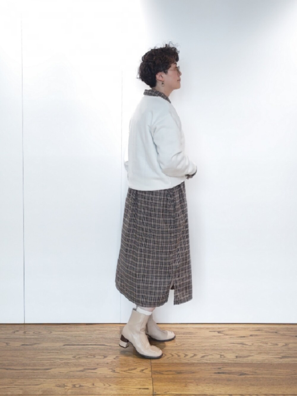 ベージュ系のハンドバッグ、ブラウン系のワンピース、グリーン系のその他アウターを着用したレディースの冬コーディネートの5枚目の写真