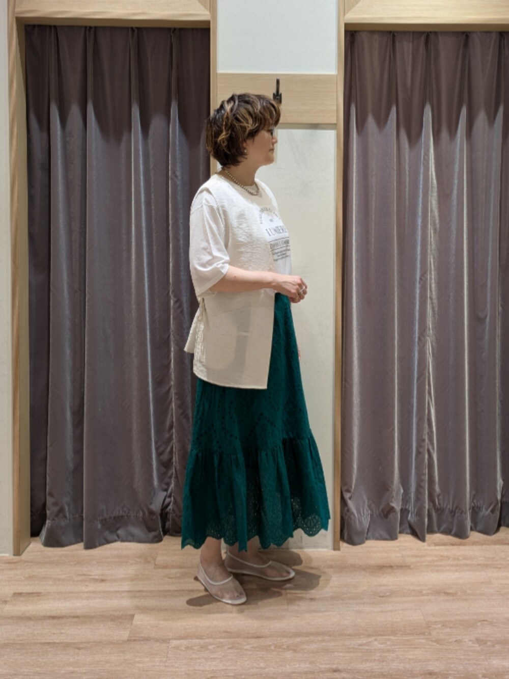 ホワイト系のその他シューズ、ホワイト系のハンドバッグ、グリーン系のスカートを着用したレディースの夏コーディネートの3枚目の写真