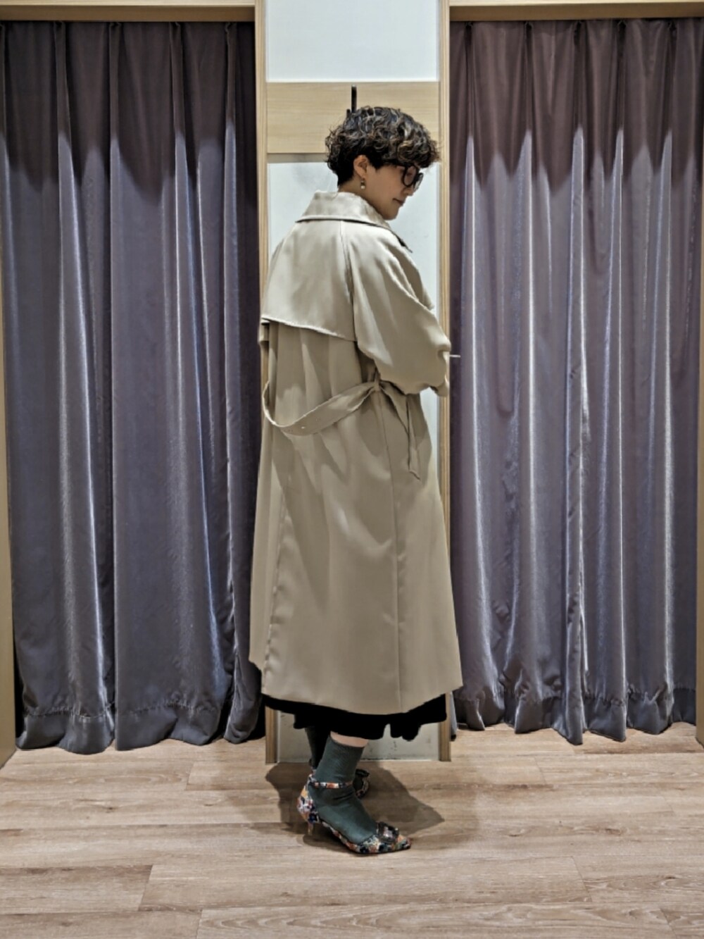 ブルー系のワンピース、ブラウン系のハンドバッグ、ホワイト系のパンプスを着用したレディースの冬コーディネートの3枚目の写真