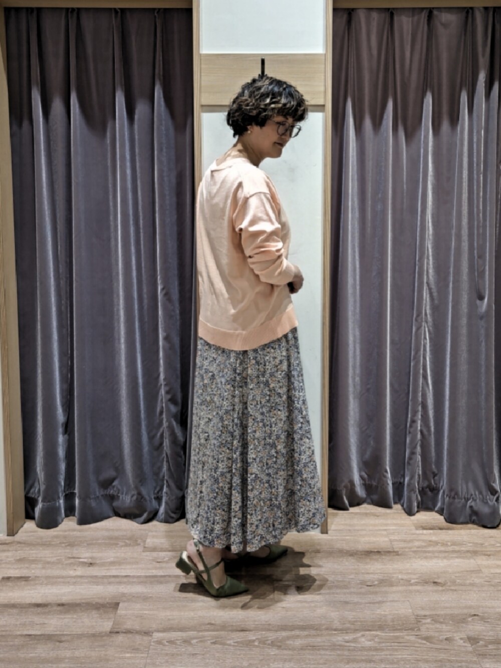 ピンク系のカーディガン/ボレロ、ブラック系のスカート、ホワイト系のハンドバッグを着用したレディースの春コーディネートの3枚目の写真