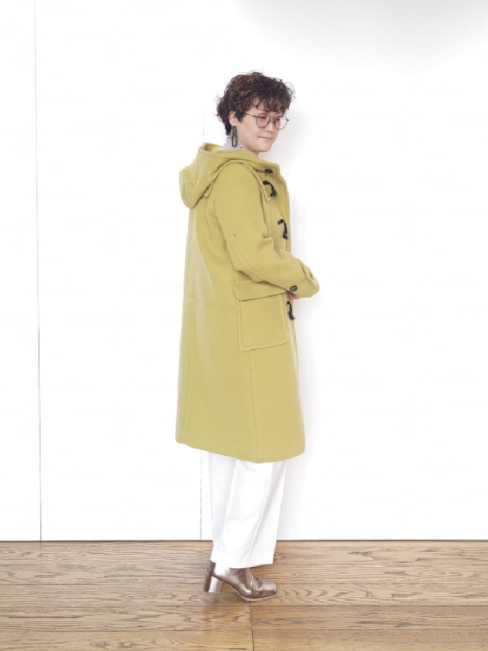 その他のブーツ、イエロー系のその他アウター、ホワイト系のその他パンツを着用したレディースの冬コーディネートの2枚目の写真