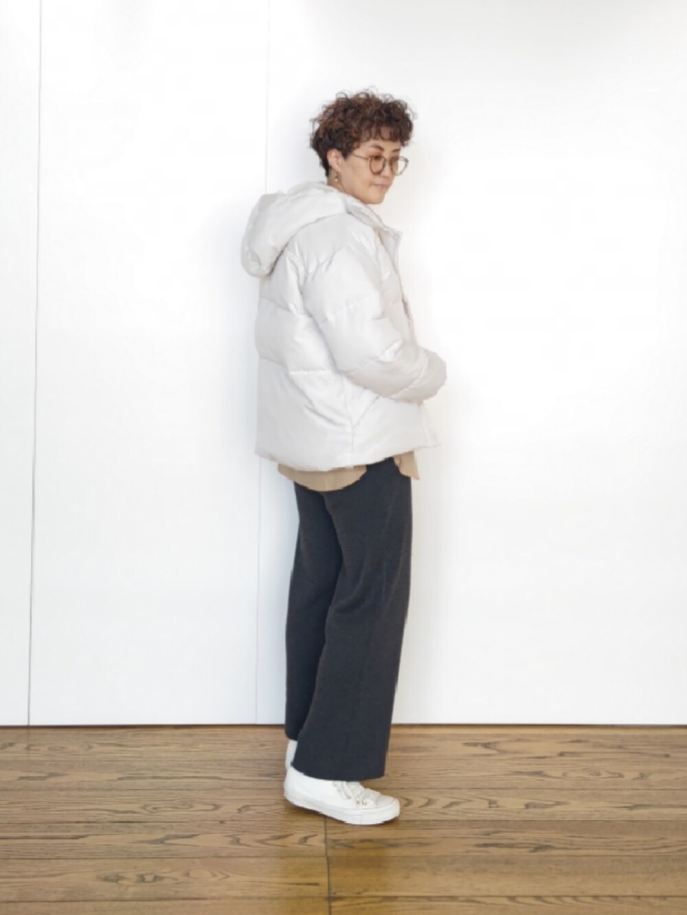 ホワイト系のハンドバッグ、ホワイト系のその他アウター、ベージュ系のシャツ/ブラウスを着用したレディースの冬コーディネートの2枚目の写真