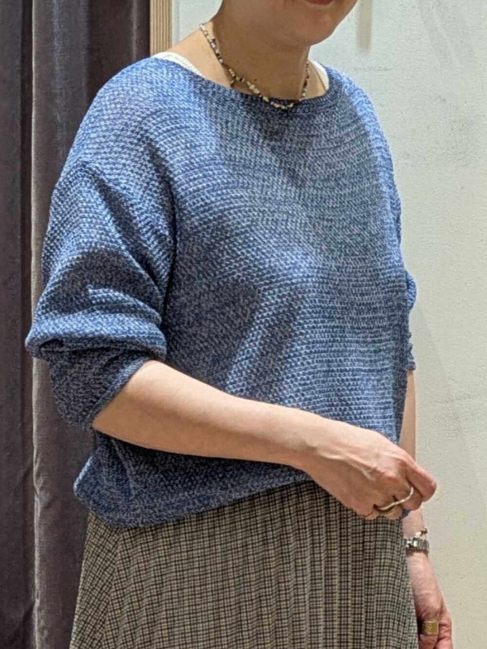 ホワイト系のパンプス、ホワイト系のハンドバッグ、ブルー系のニット/セーターを着用したレディースの春コーディネートの2枚目の写真