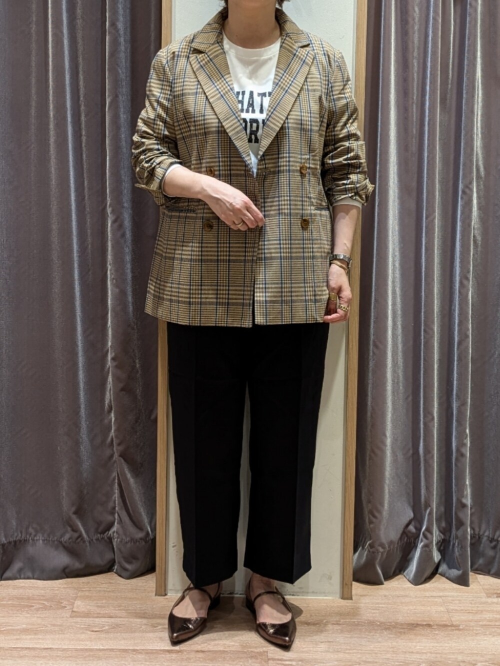 ブラウン系のハンドバッグ、ブルー系のその他パンツ、ホワイト系のTシャツ/カットソーを着用したレディースの秋コーディネートの2枚目の写真