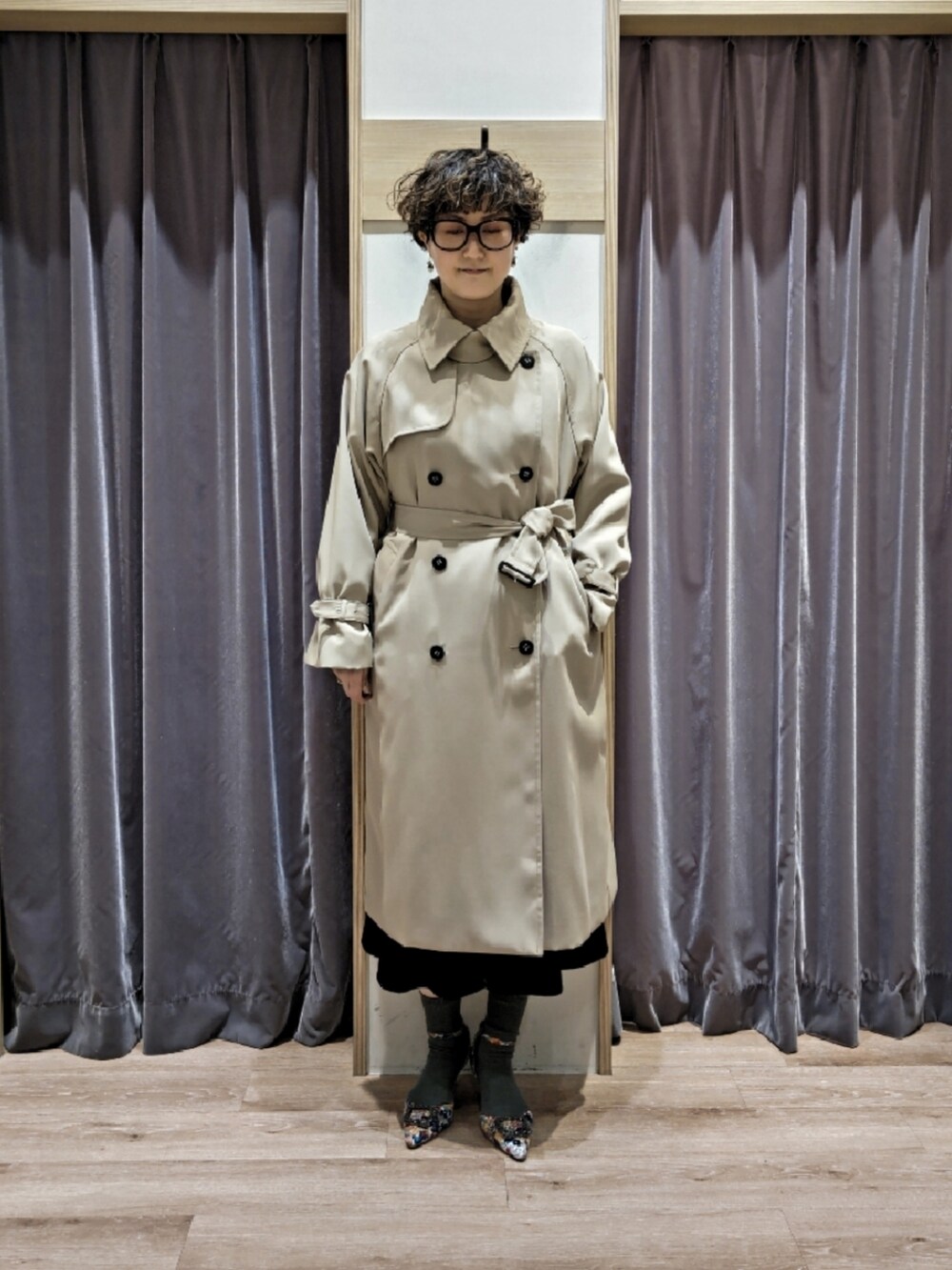 ブルー系のワンピース、ブラウン系のハンドバッグ、ホワイト系のパンプスを着用したレディースの冬コーディネートの4枚目の写真