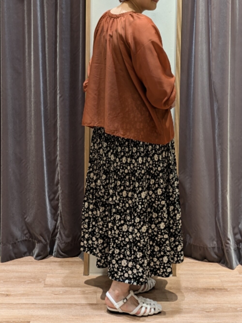 オレンジ系のシャツ/ブラウス、ブラック系のスカート、ブラック系のハンドバッグを着用したレディースの夏コーディネートの3枚目の写真
