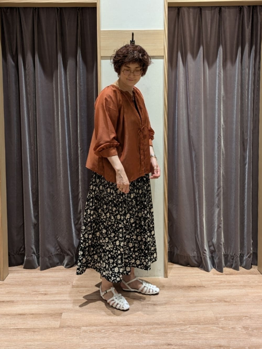 オレンジ系のシャツ/ブラウス、ブラック系のスカート、ブラック系のハンドバッグを着用したレディースの夏コーディネートの2枚目の写真