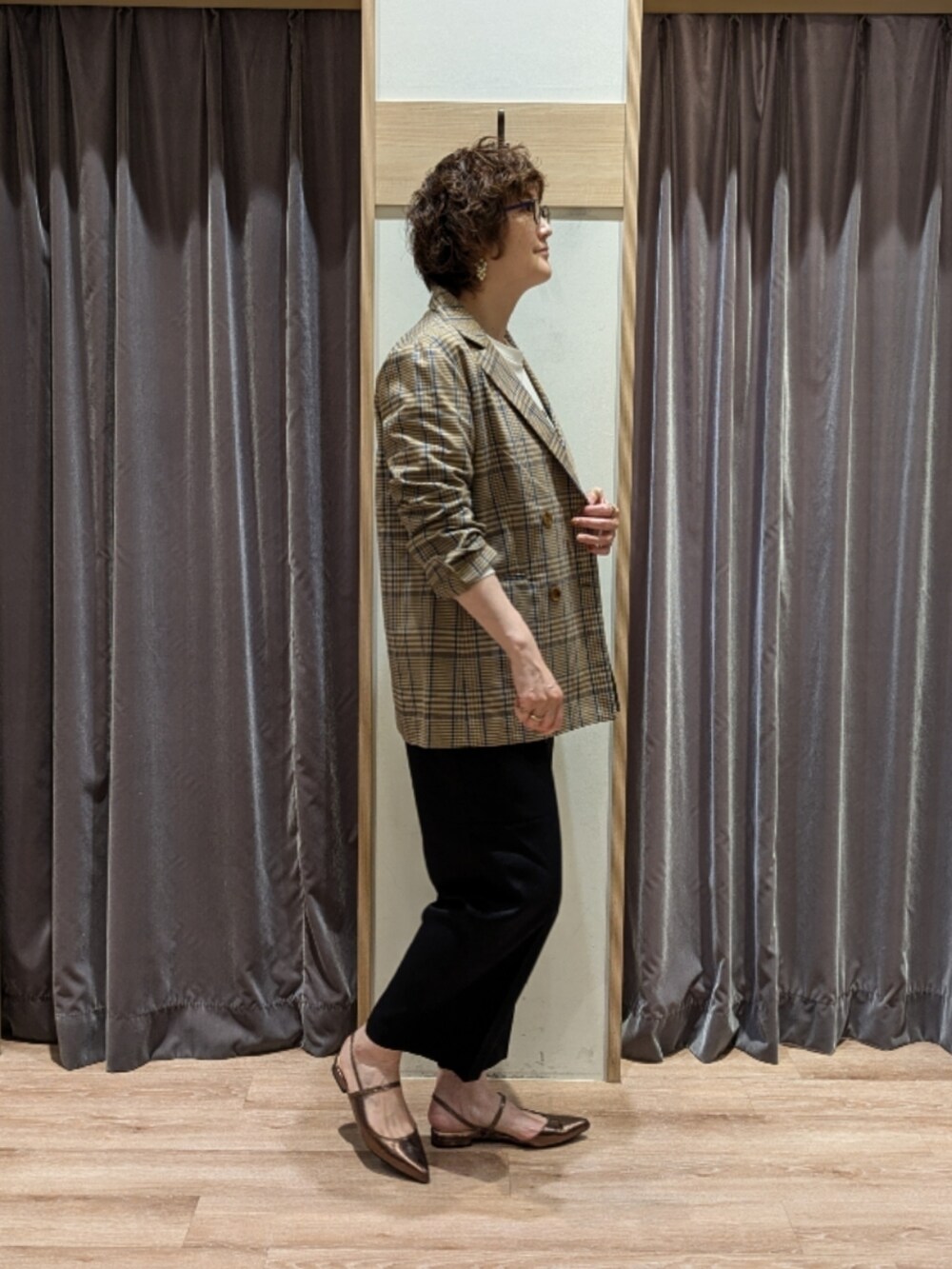 ブラウン系のハンドバッグ、ブルー系のその他パンツ、ホワイト系のTシャツ/カットソーを着用したレディースの秋コーディネートの3枚目の写真