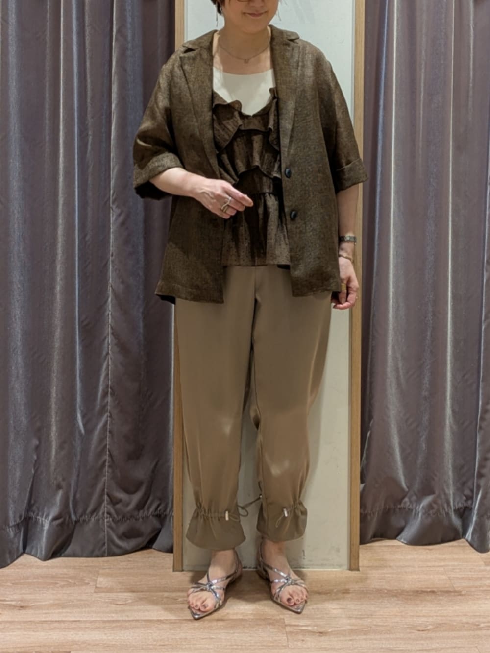 シルバー系のサンダル、ブラウン系のその他パンツ、ホワイト系のハンドバッグを着用したレディースの春コーディネートの2枚目の写真