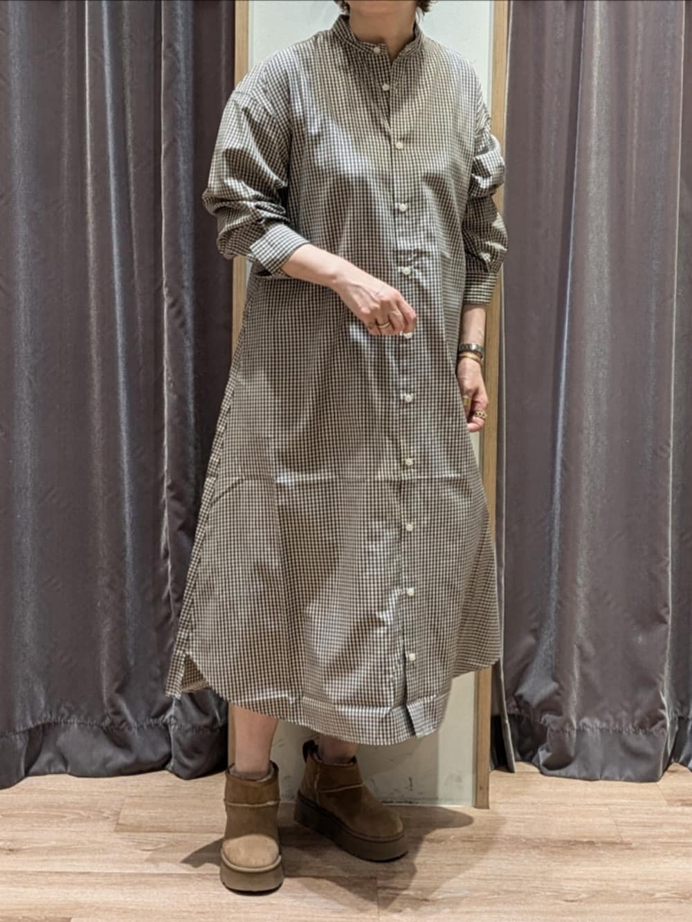 ブラウン系のワンピース、ホワイト系のハンドバッグ、ベージュ系のブーツを着用したレディースの秋コーディネートの4枚目の写真