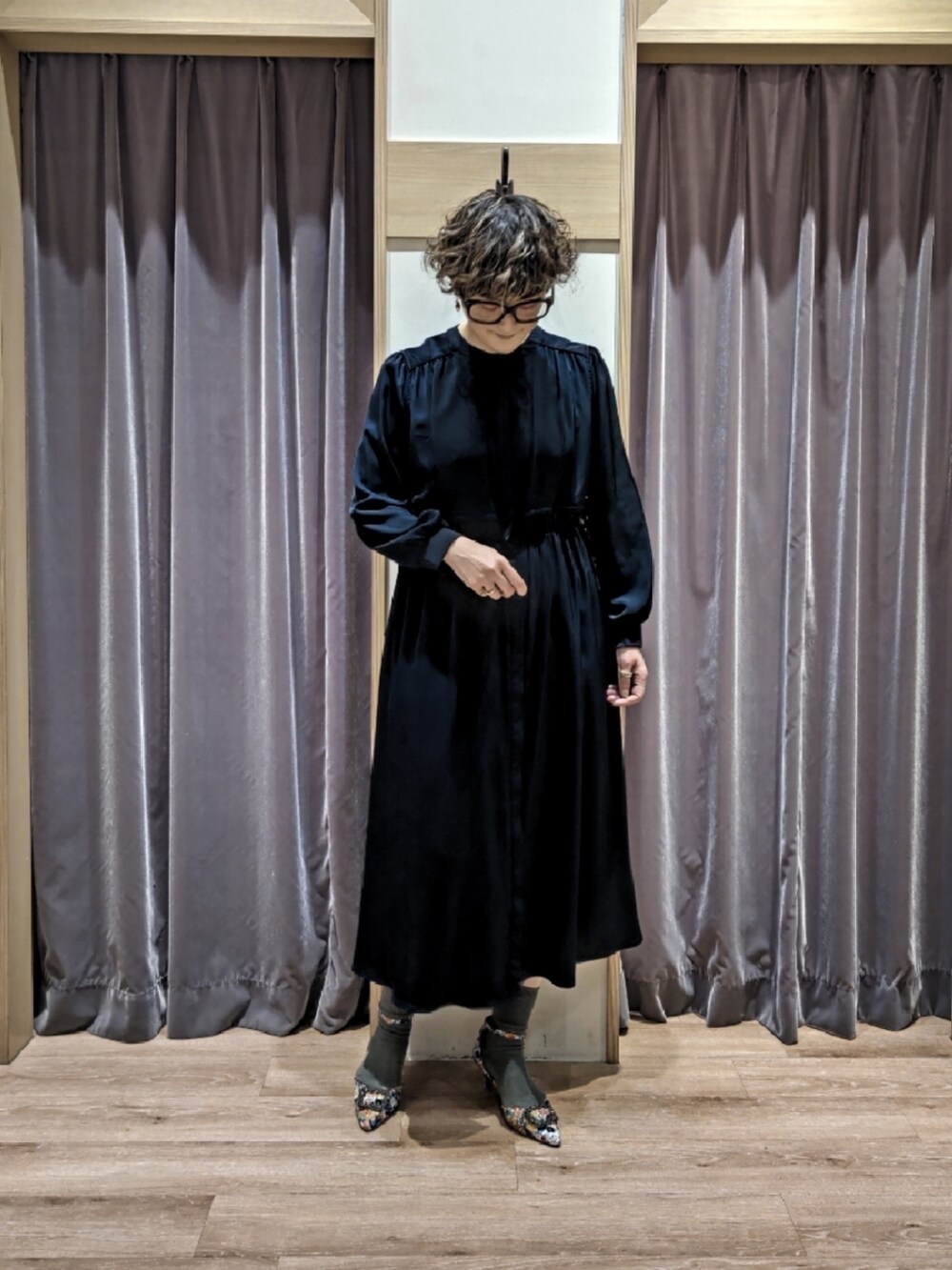 ブルー系のワンピース、ブラウン系のハンドバッグ、ホワイト系のパンプスを着用したレディースの冬コーディネートの5枚目の写真