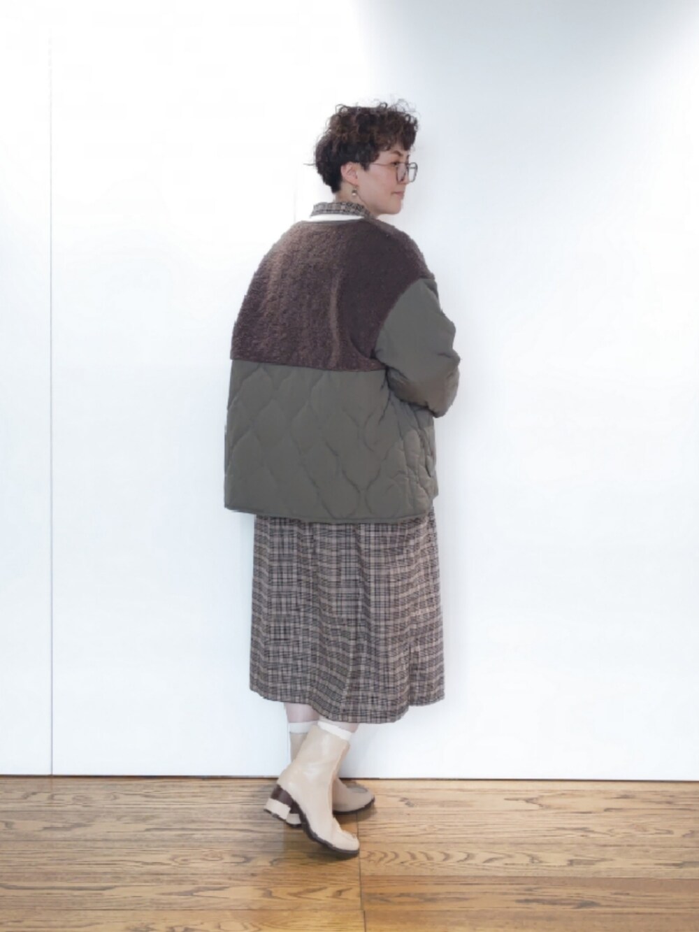 ベージュ系のハンドバッグ、ブラウン系のワンピース、グリーン系のその他アウターを着用したレディースの冬コーディネートの3枚目の写真