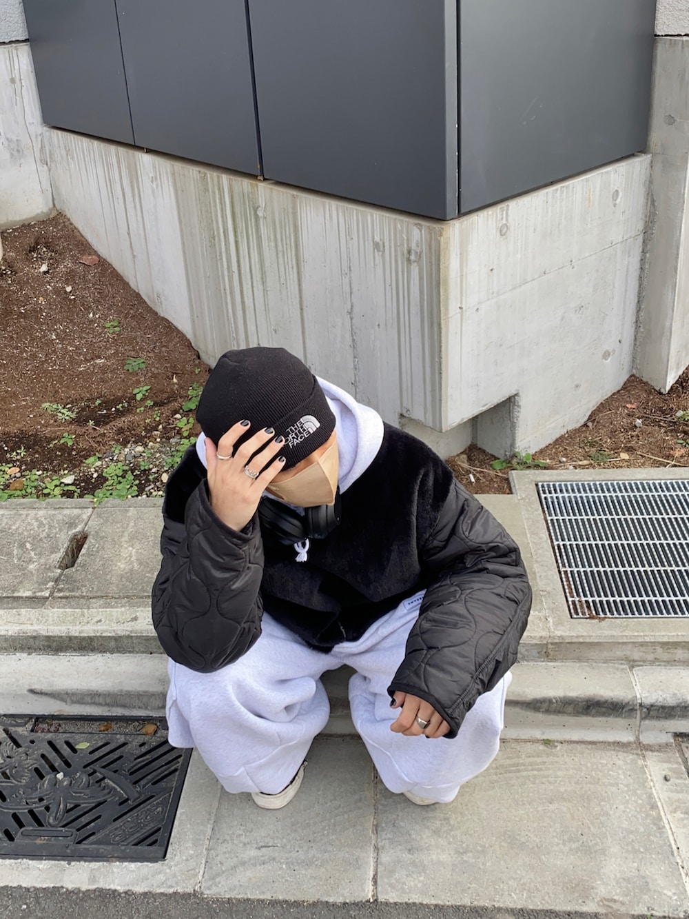 ブラック系のモッズコート、ホワイト系のスウェットパンツ、ブラック系のスニーカーを着用したメンズの冬コーディネートの3枚目の写真