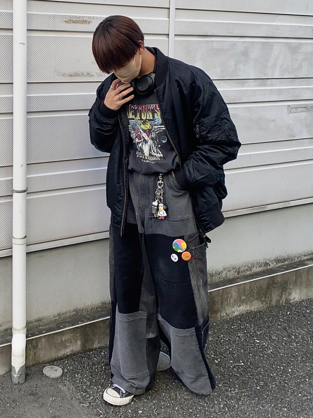 ブラック系のTシャツ/カットソー、ブラック系のスニーカー、ブラック系のデニムパンツを着用したメンズの秋コーディネートの2枚目の写真