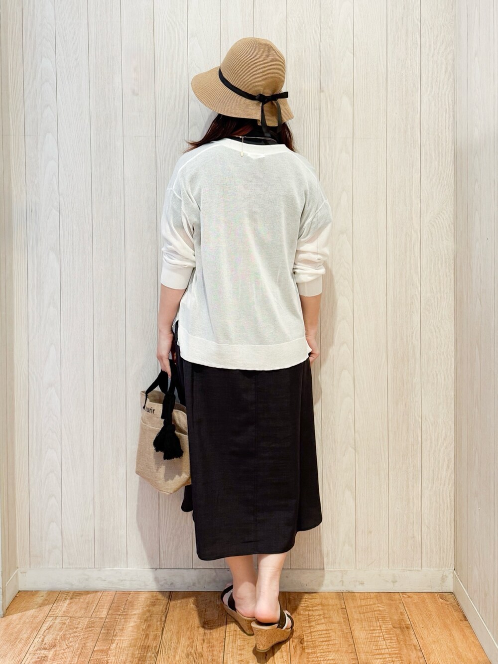 グレー系のワンピース、ホワイト系のカーディガン/ボレロ、ブラック系のサンダルを着用したレディースの春コーディネートの3枚目の写真