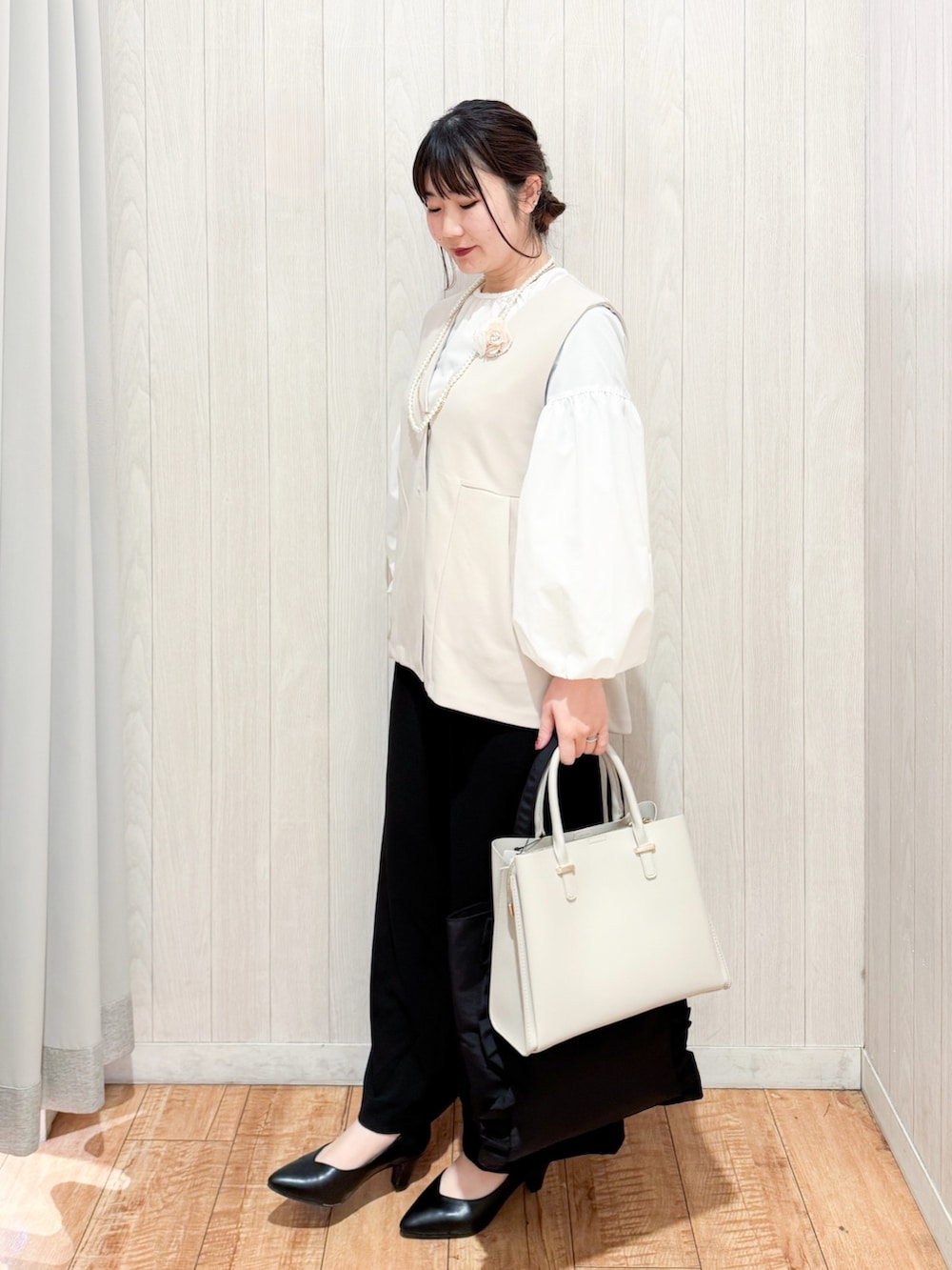 ベージュ系のベスト、ホワイト系のシャツ/ブラウス、ブラック系のその他パンツを着用したレディースの冬コーディネートの2枚目の写真