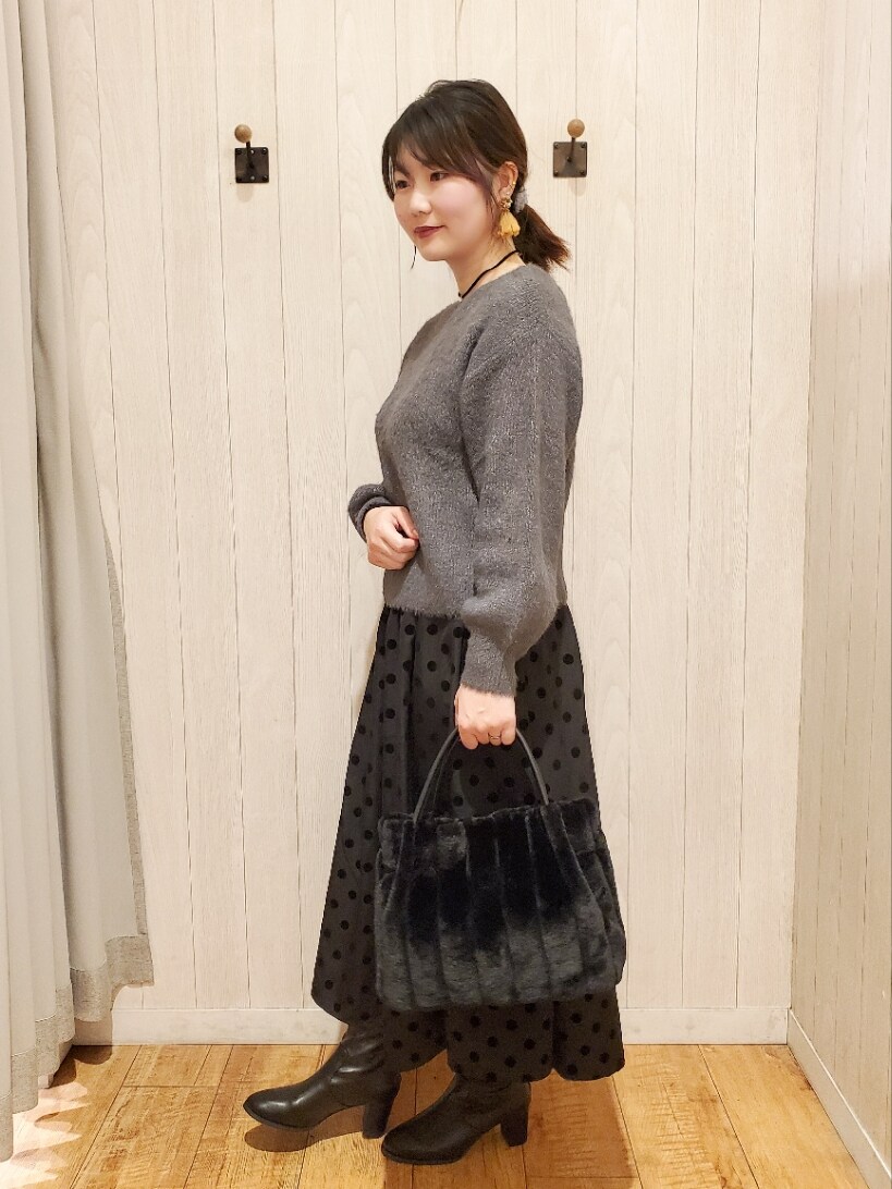 グレー系のニット/セーター、ブラック系のトートバッグ、グレー系のスカートを着用したレディースの冬コーディネートの2枚目の写真