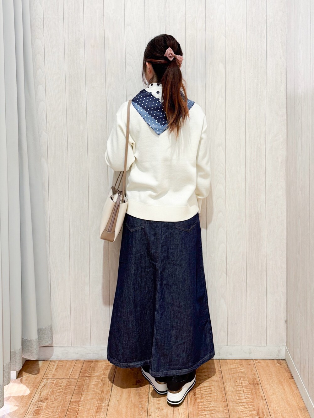 ホワイト系のニット/セーター、ブラック系のスニーカー、ブルー系のデニムスカートを着用したレディースの冬コーディネートの3枚目の写真