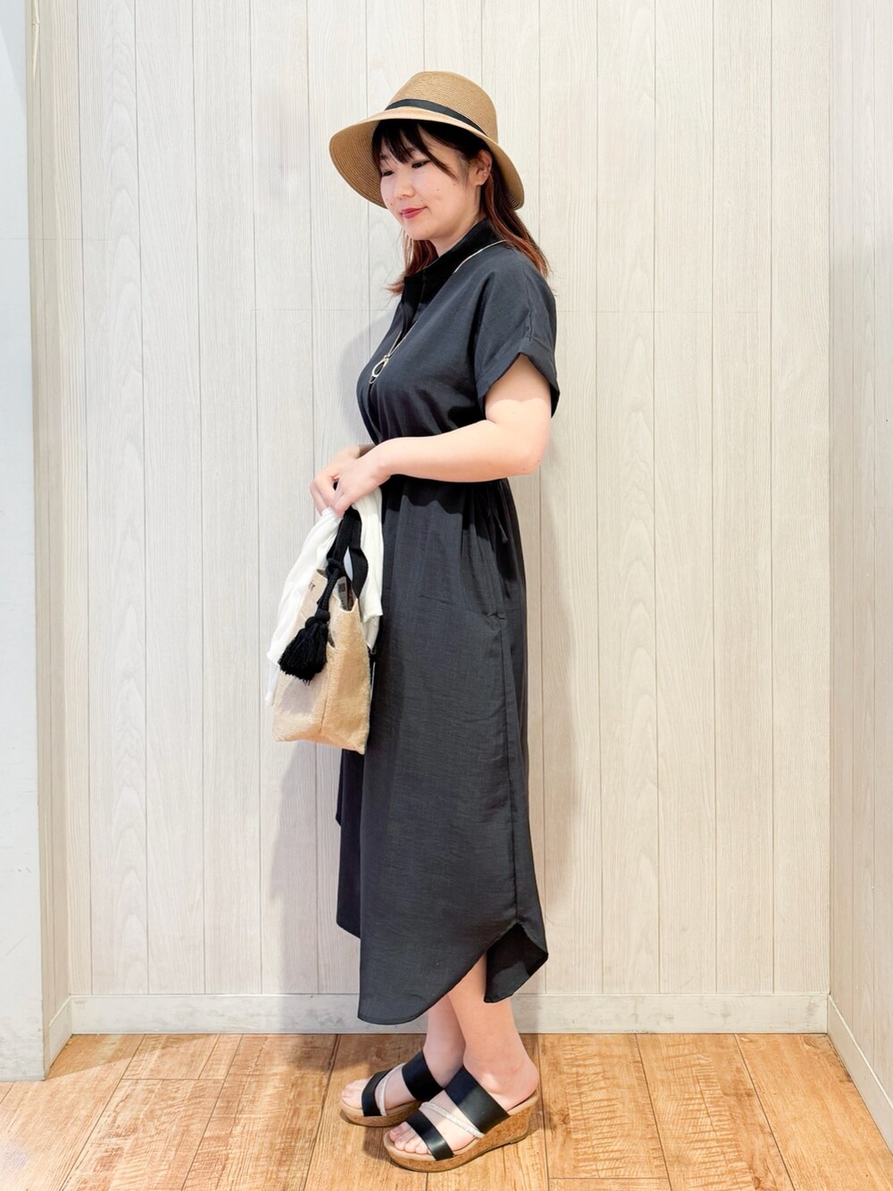 グレー系のワンピース、ホワイト系のカーディガン/ボレロ、ブラック系のサンダルを着用したレディースの春コーディネートの5枚目の写真
