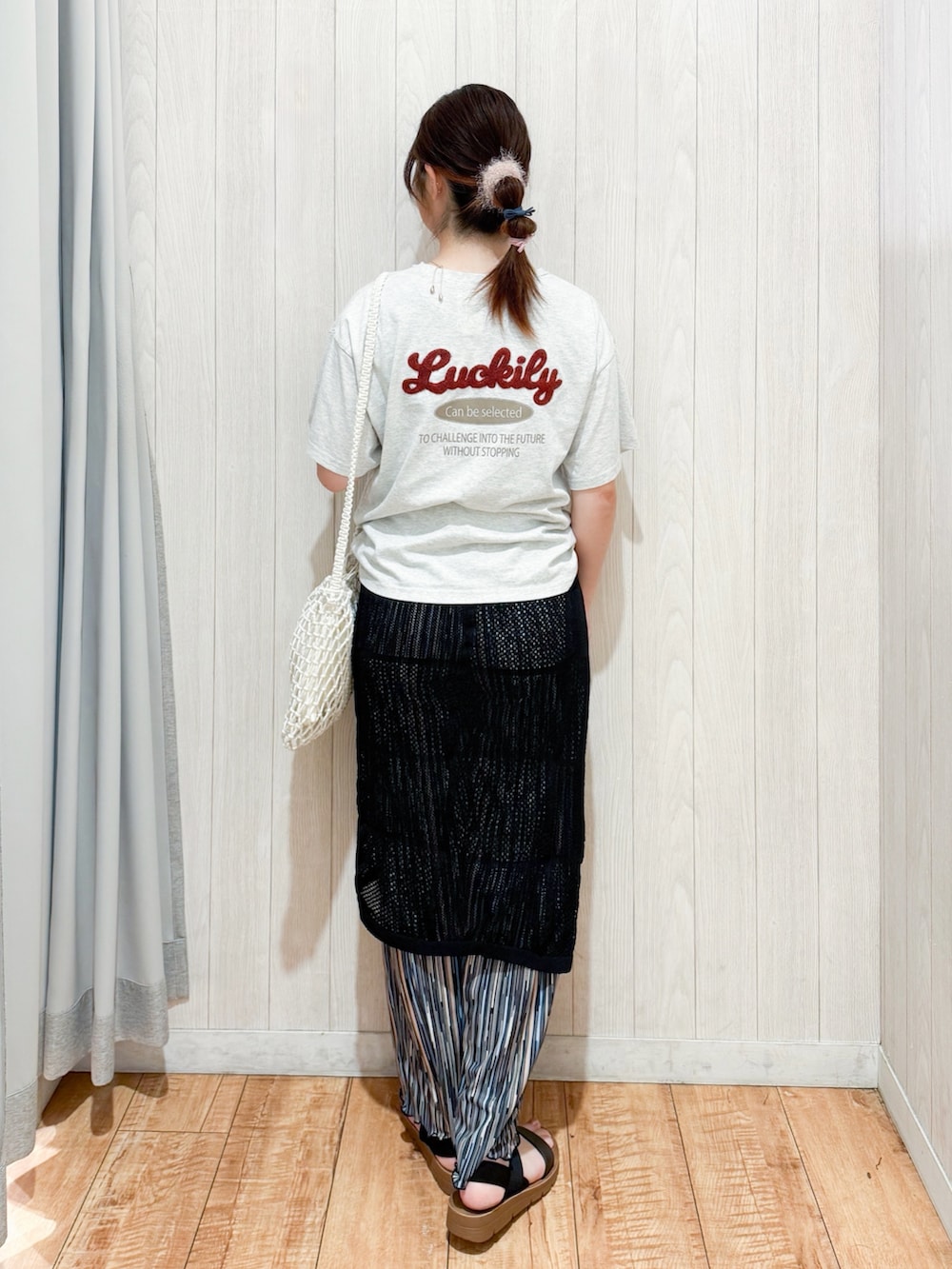 ホワイト系のTシャツ/カットソー、ブラック系のスカート、ホワイト系のショルダーバッグを着用したレディースの夏コーディネートの3枚目の写真