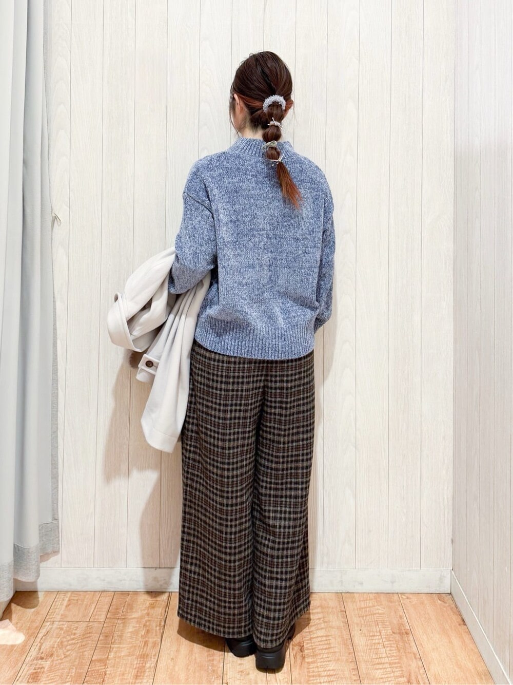 ベージュ系のチェスターコート、ブルー系のニット/セーター、ブラック系のその他パンツを着用したレディースの冬コーディネートの5枚目の写真