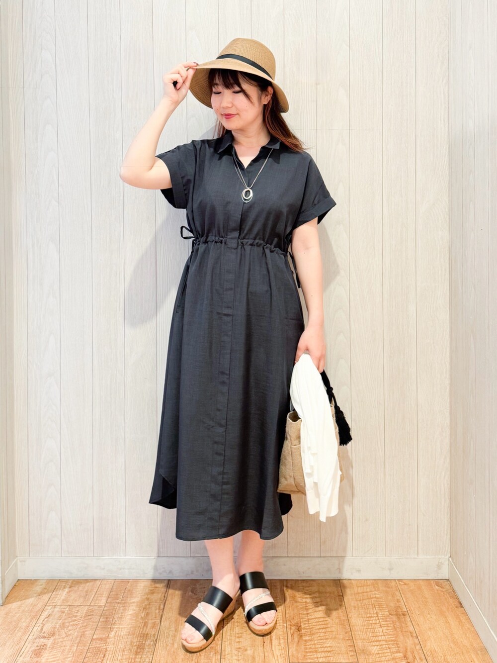 グレー系のワンピース、ホワイト系のカーディガン/ボレロ、ブラック系のサンダルを着用したレディースの春コーディネートの4枚目の写真