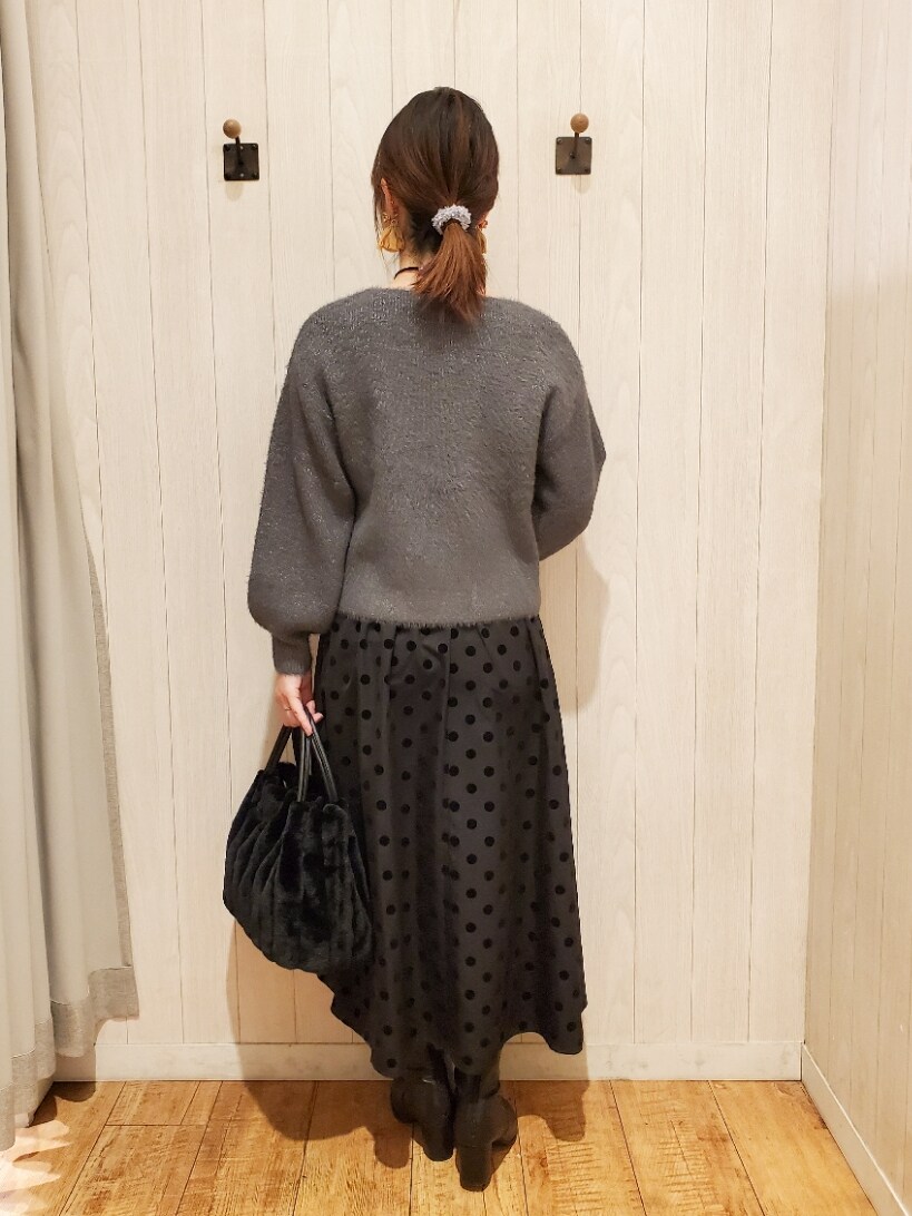 グレー系のニット/セーター、ブラック系のトートバッグ、グレー系のスカートを着用したレディースの冬コーディネートの3枚目の写真