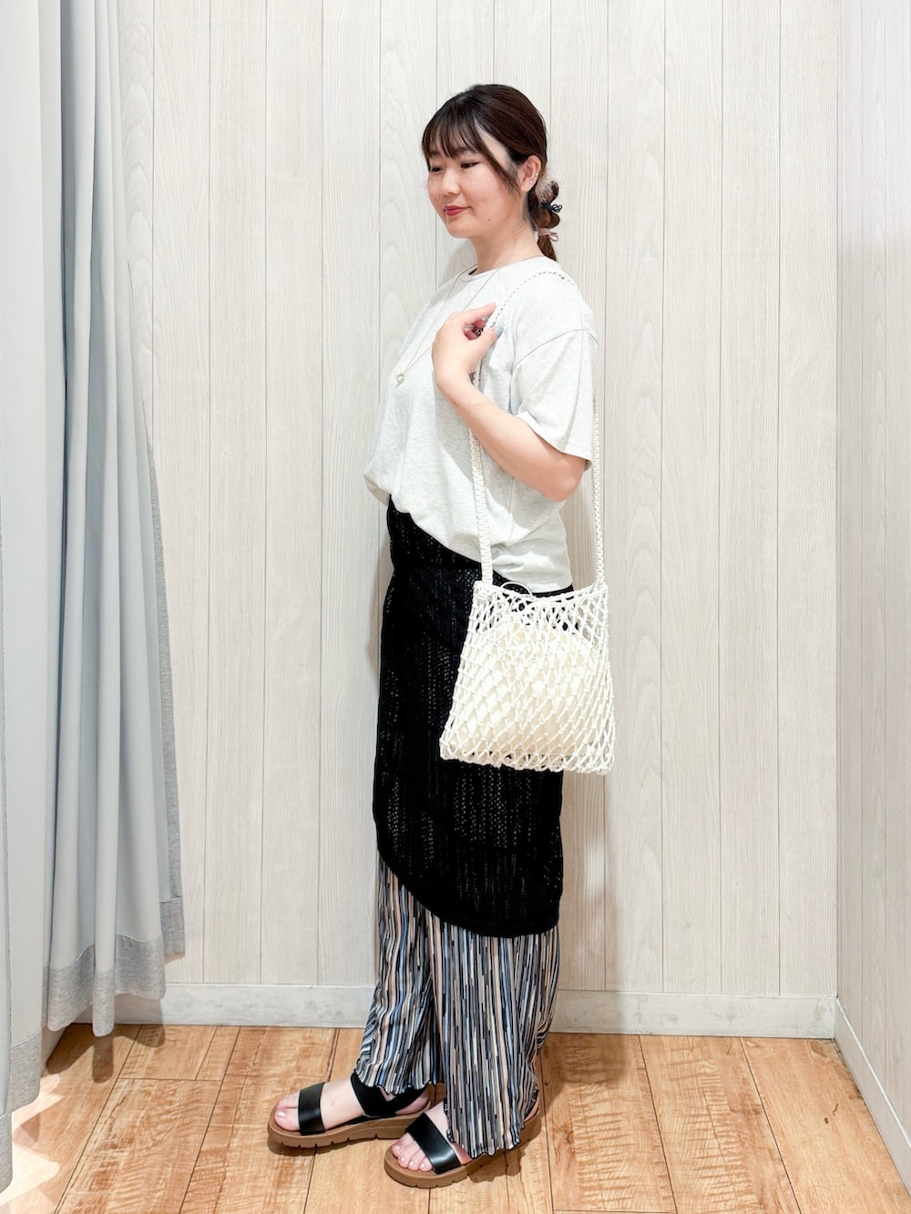 ホワイト系のTシャツ/カットソー、ブラック系のスカート、ホワイト系のショルダーバッグを着用したレディースの夏コーディネートの2枚目の写真