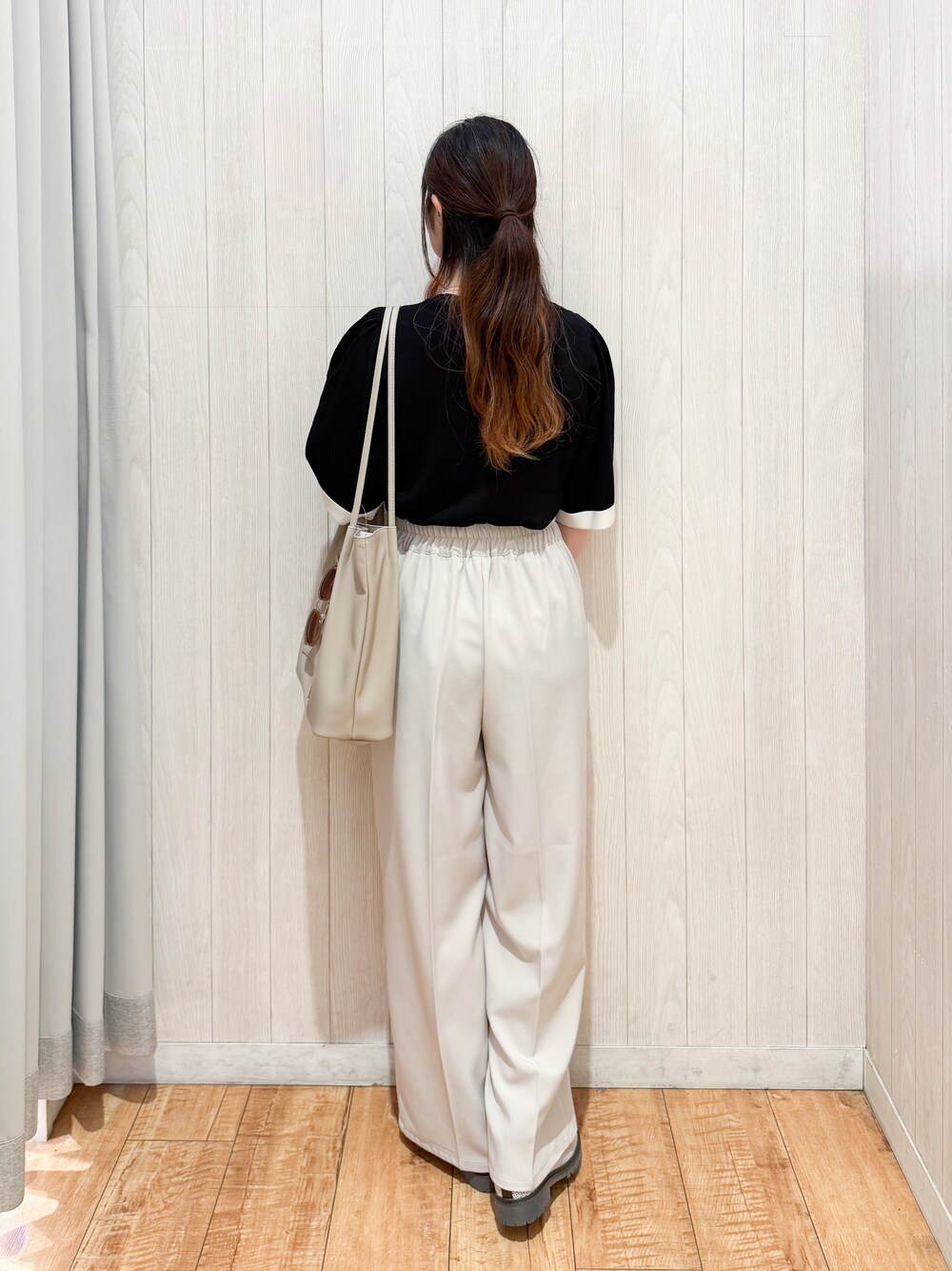ブラック系のニット/セーター、ベージュ系のその他パンツ、ブラウン系のパンプスを着用したレディースの春コーディネートの3枚目の写真