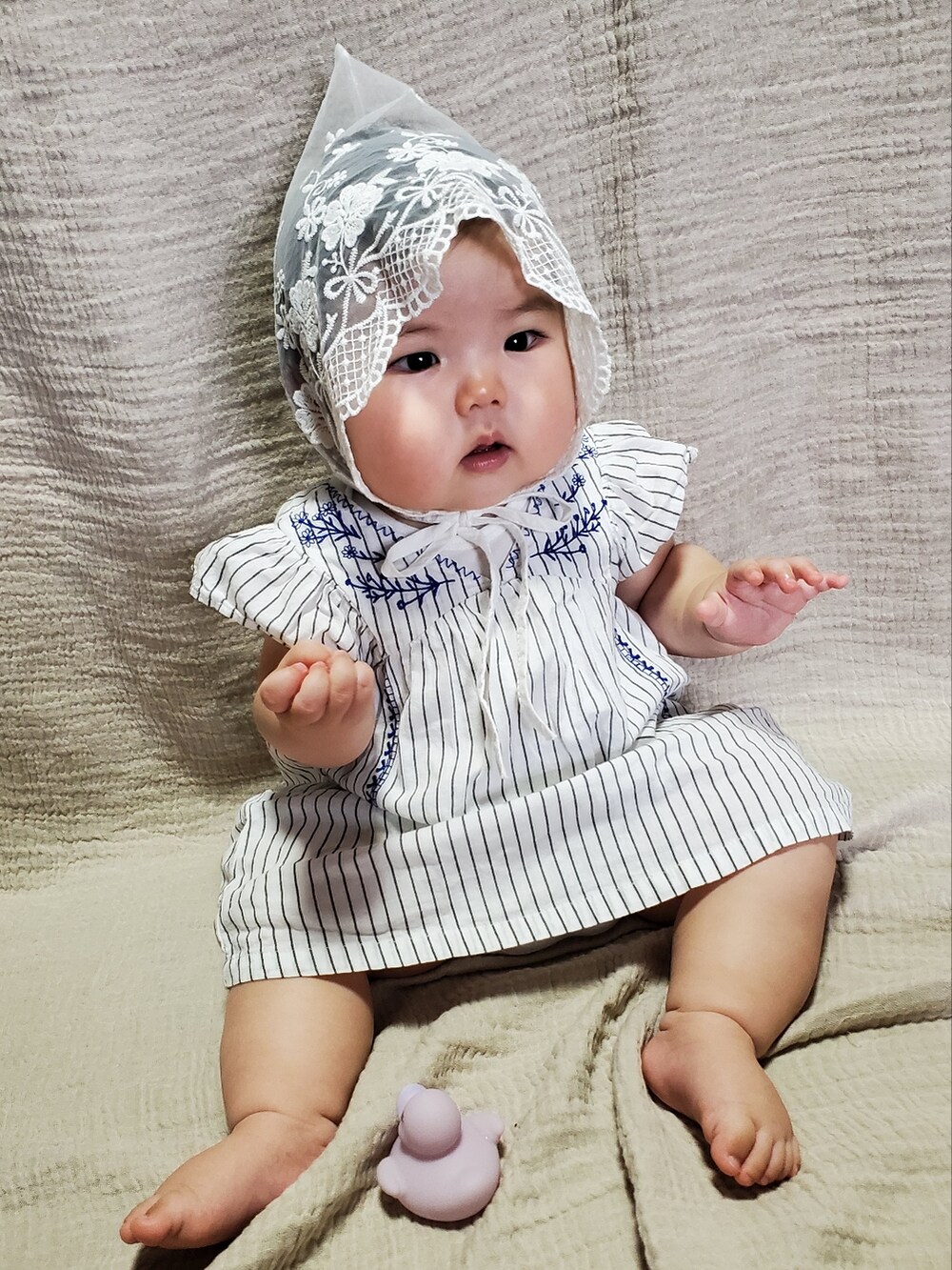 ホワイト系のワンピース、ホワイト系の帽子を着用したキッズの秋コーディネートの2枚目の写真