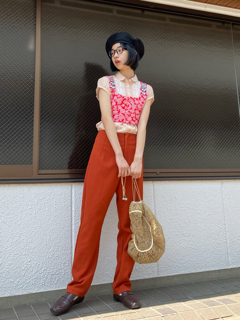 レッド系のチューブトップ、オレンジ系のパンツを着用したレディースの夏コーディネートの2枚目の写真