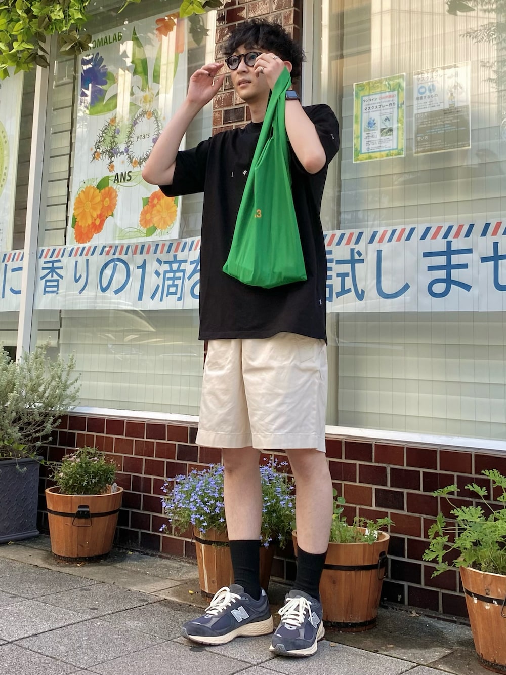 ブラック系のTシャツ/カットソー、ホワイト系のパンツ、ブルー系のスニーカーを着用したメンズの夏コーディネートの2枚目の写真